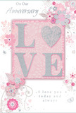 This anniversary card offers a gentle celebration of enduring romance, its design as soft and intimate as a quiet walk through Lower Clapton's tree-lined streets. The centrepiece is the word LOVE, rendered in raised, softly glittered letters, with the O transformed into a shimmering silver heart that anchors the entire composition. The glitter is fine and delicate, catching the light in a subtle way that feels refined rather than flashy, much like a candlelit dinner at home. Around this central motif, delicate flowers in blush pink, mauve, and pale ivory unfurl with a watercolour-like softness, their edges defined by fine, flowing outlines. Slender vines curl between the blooms, and small flourishes-scattered petals, gentle swirls, and discreet butterfly shapes-give a sense of movement, as if a light breeze were drifting through an English spring garden near Clapton Pond. The background remains in a soft pastel pink with hints of silvery grey, creating a soothing, cohesive palette that enhances the romantic tone. Above and alongside the floral design, the words On Our Anniversary and I love you today and always appear in an elegant, understated script, echoing the sincerity of long-held affection and shared memories. The layout feels balanced and uncluttered, allowing the heart-shaped O and surrounding flowers to stand out without overwhelming the eye. Overall, the card has the same carefully considered feel as a hand-arranged anniversary bouquet prepared by a local Lower Clapton florist-a keepsake that quietly honours a shared journey, ready to be given alongside fresh blooms delivered to the door.